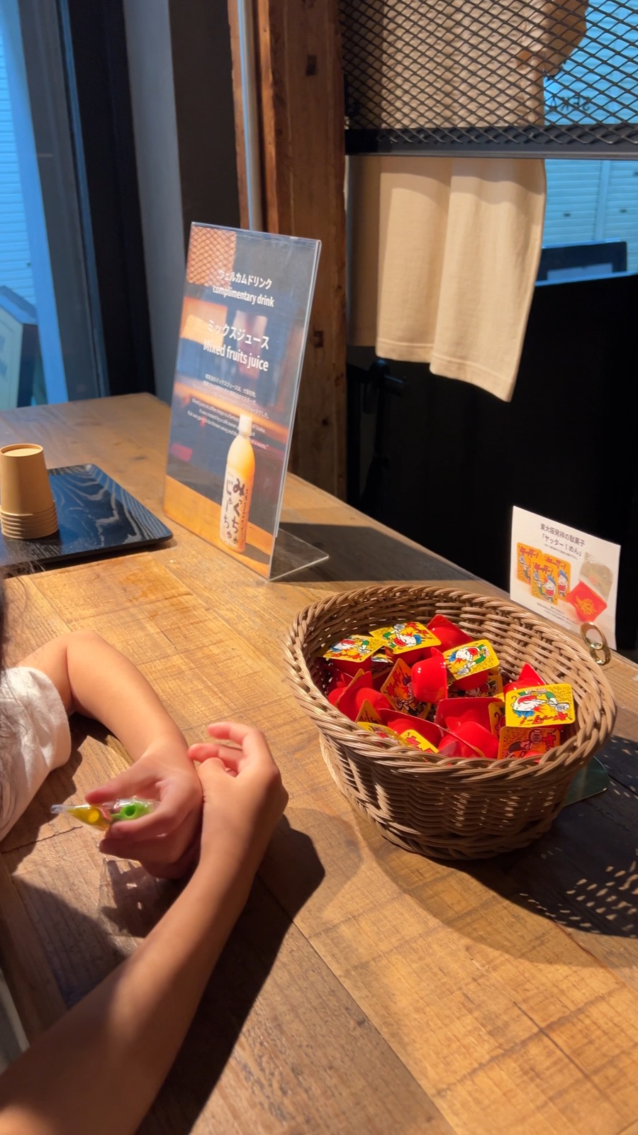 ウェルカムドリンクの案内と駄菓子が入ったかご