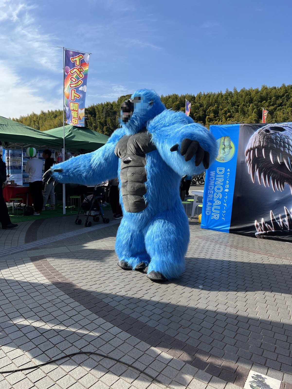 「イベント開催中」ののぼりと、青いもこもこの着ぐるみのキャラクター