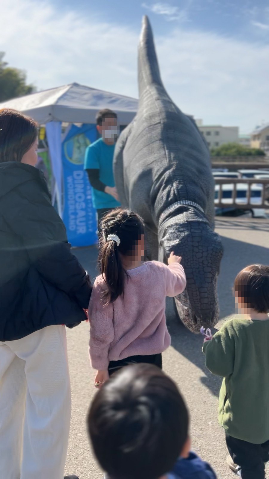 大きな恐竜の模型に手をのばす子ども