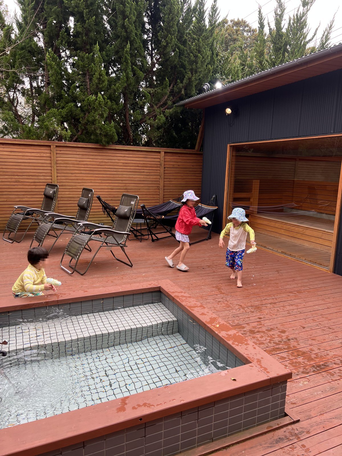 ウッドデッキにある水風呂で水遊びをする子どもたち