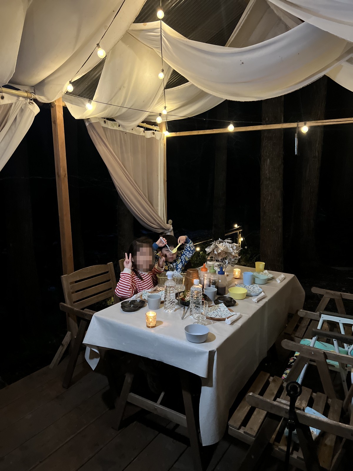 白い天蓋とライトで飾られた夜のダイニング