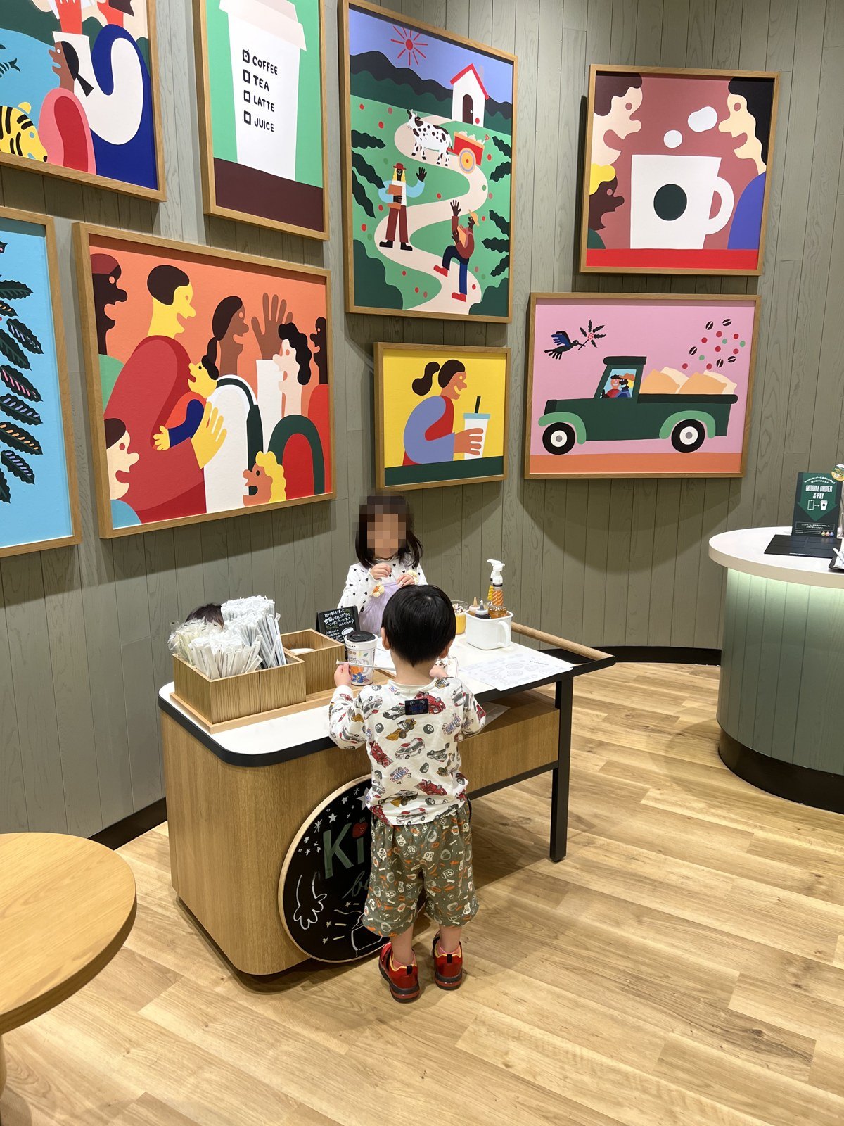 イラストが並ぶ壁と、子ども用の低いテーブル