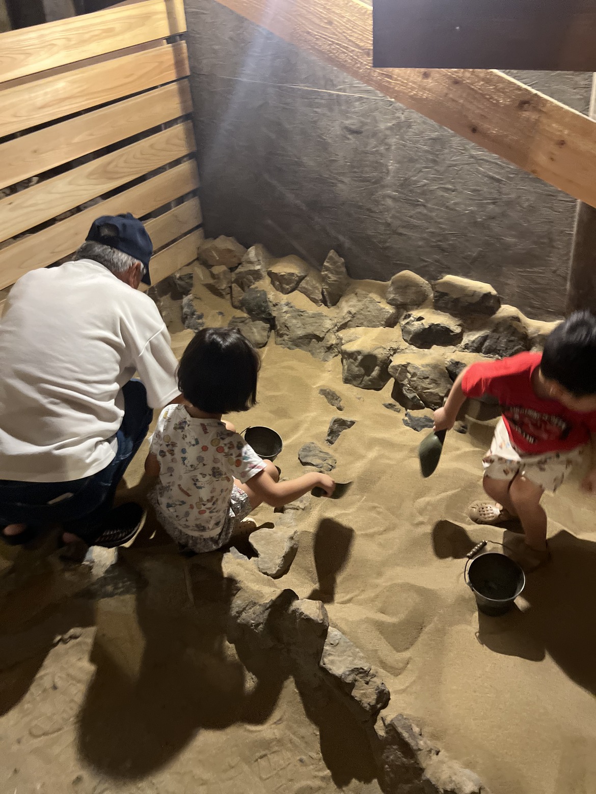 砂の中から石を掘り出す