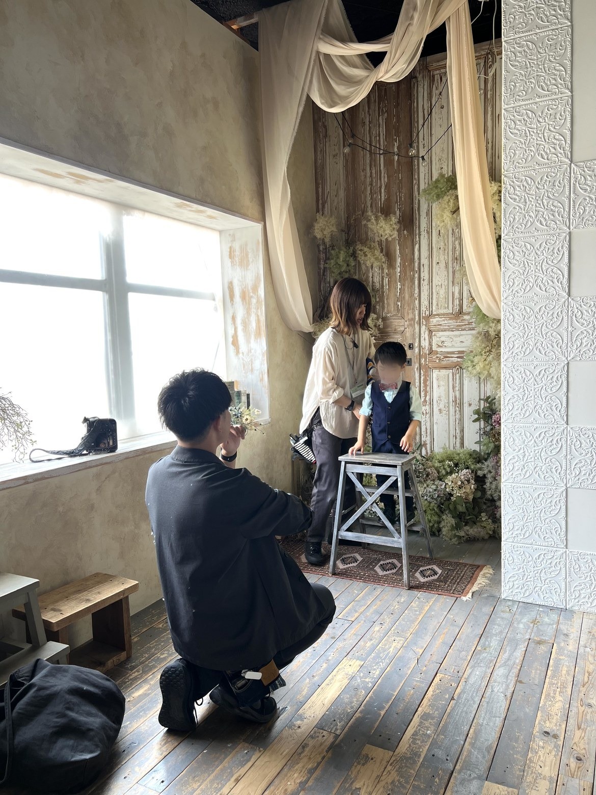 カメラマンが子どもの目線までしゃがんで撮っているところ