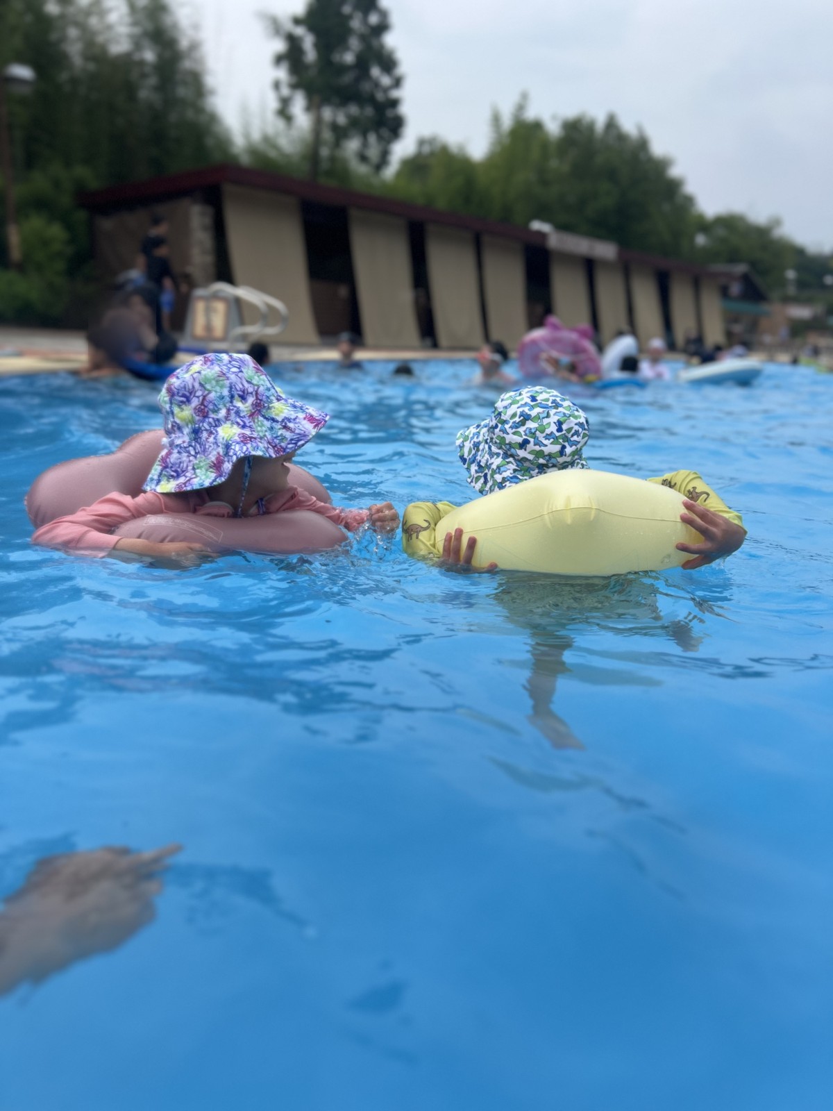 浮き輪で波のプールに浮かぶ子どもたち