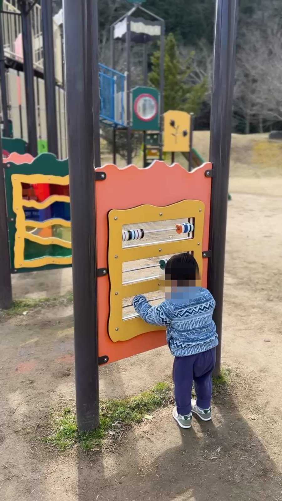 そろばんのような手で動かすパネルで遊ぶ子ども