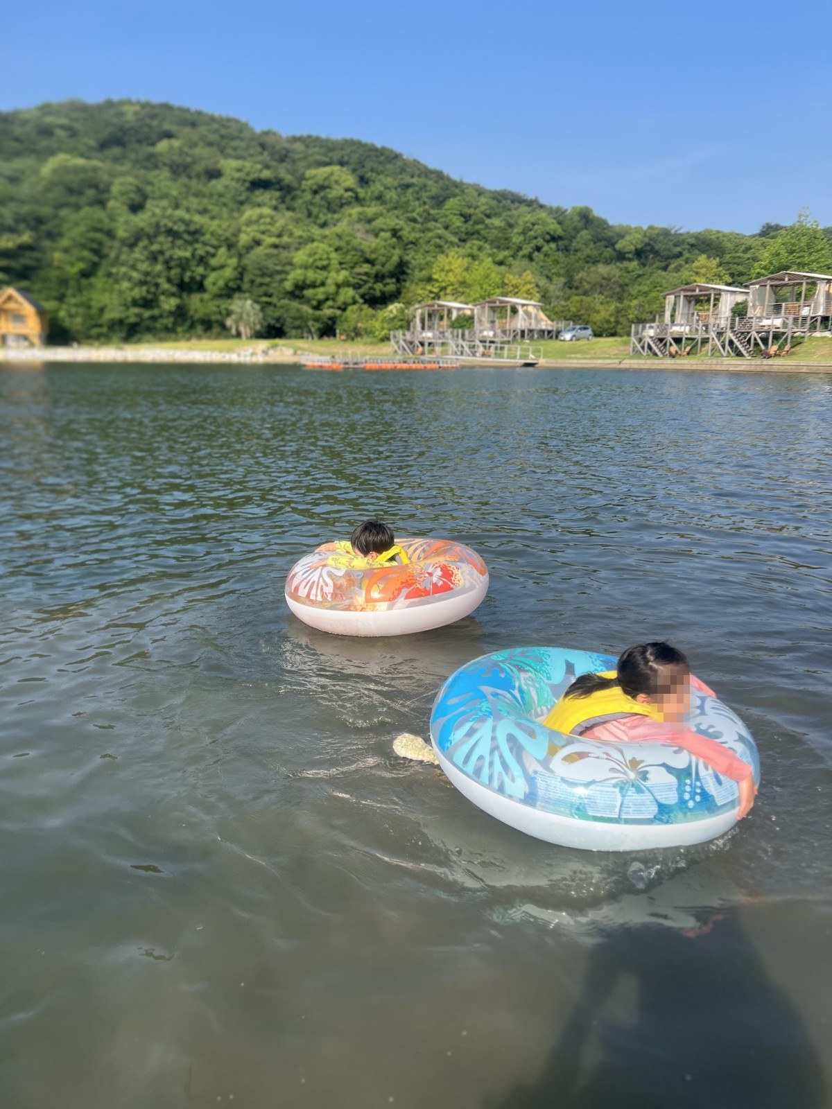 借りた浮き輪で水に浮かぶ子どもたち