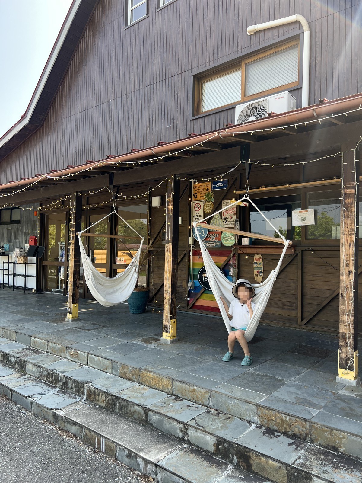 建物の軒下のハンモックに座る子ども