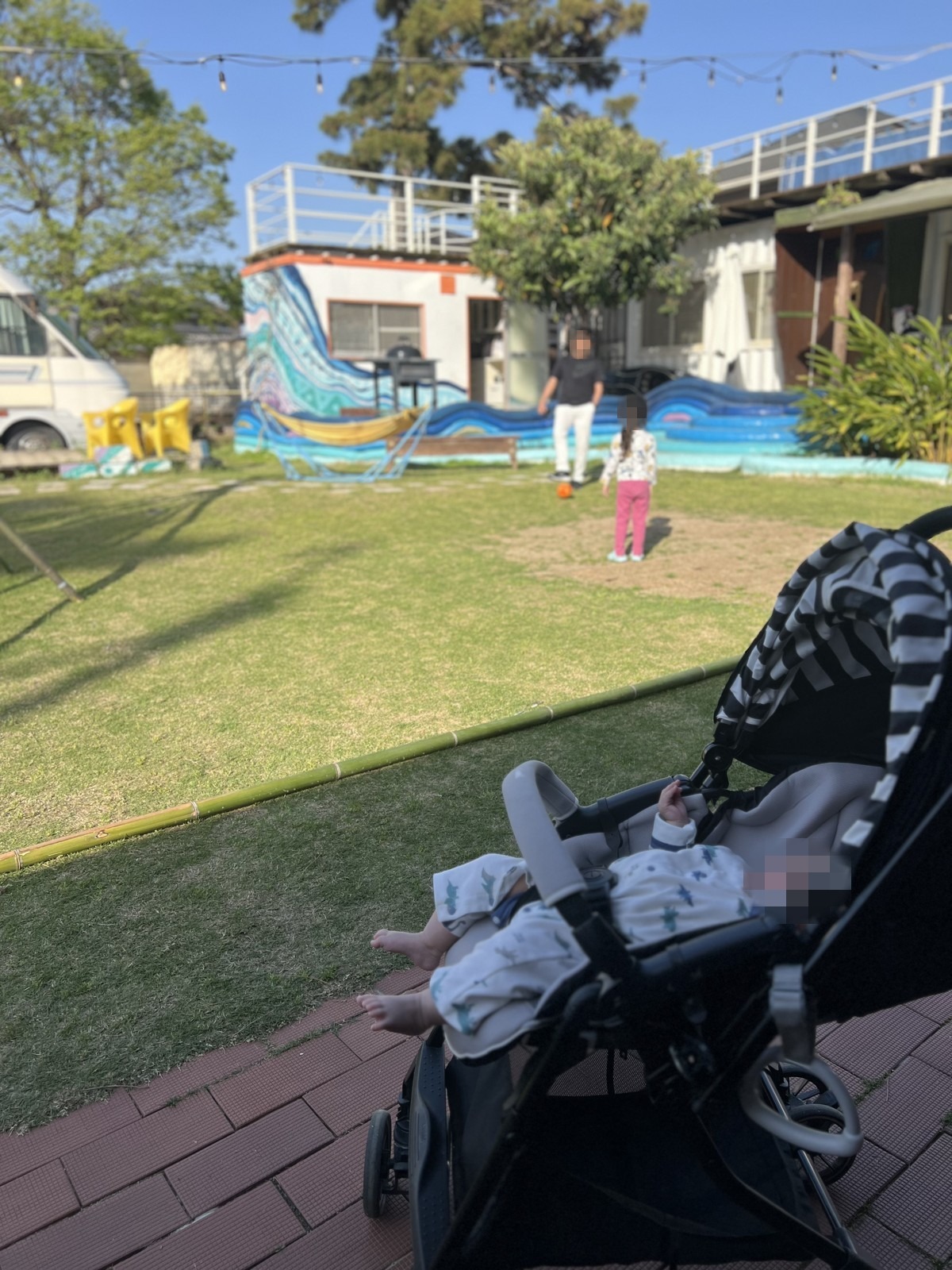 ベビーカーに乗せた下の子と芝生