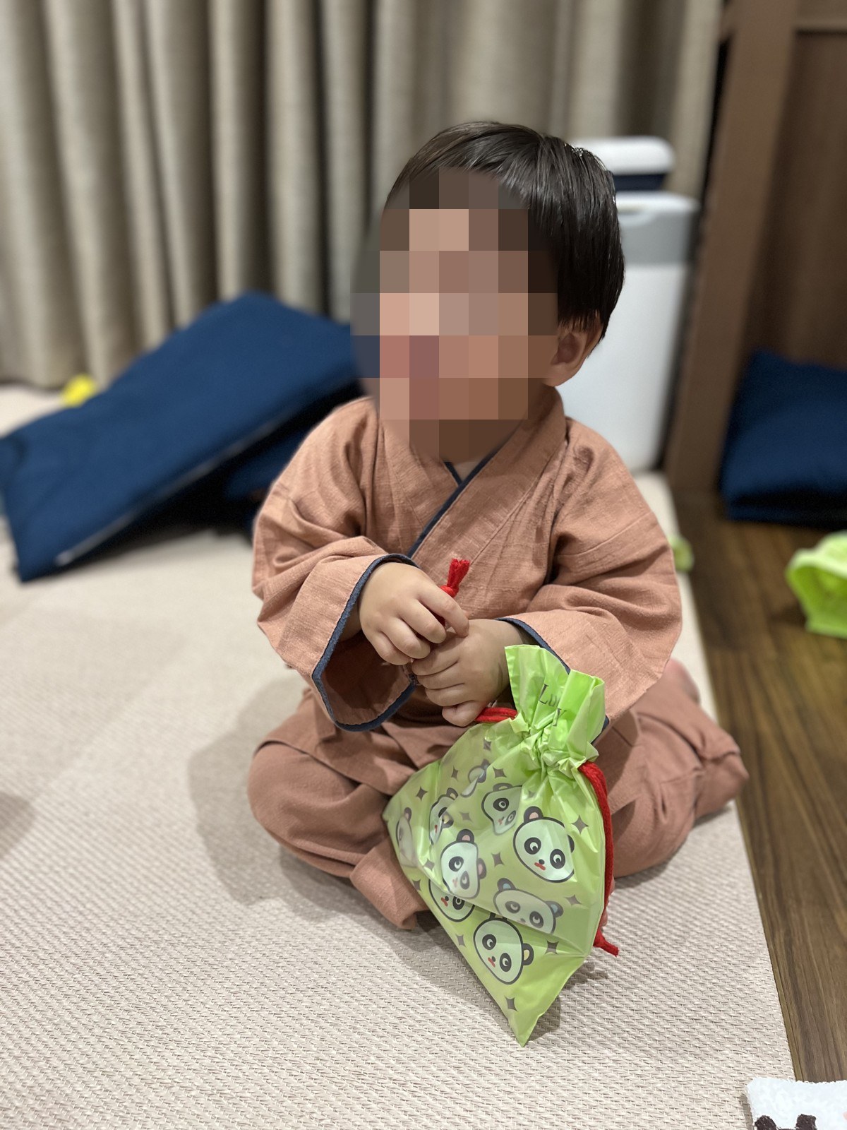 作務衣を着て床に座る1歳の子