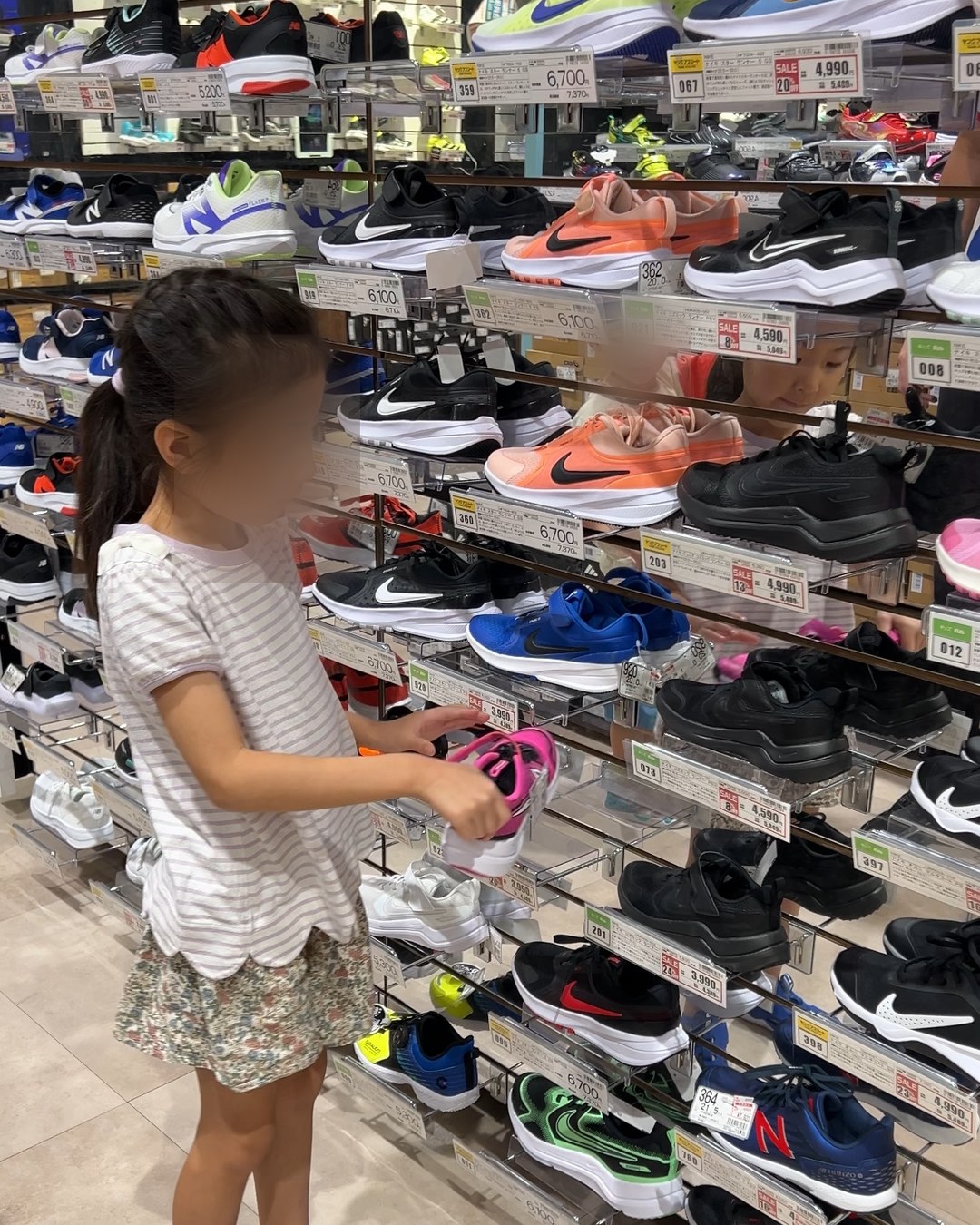 子どもが売り場でスニーカーを手に取っているところ