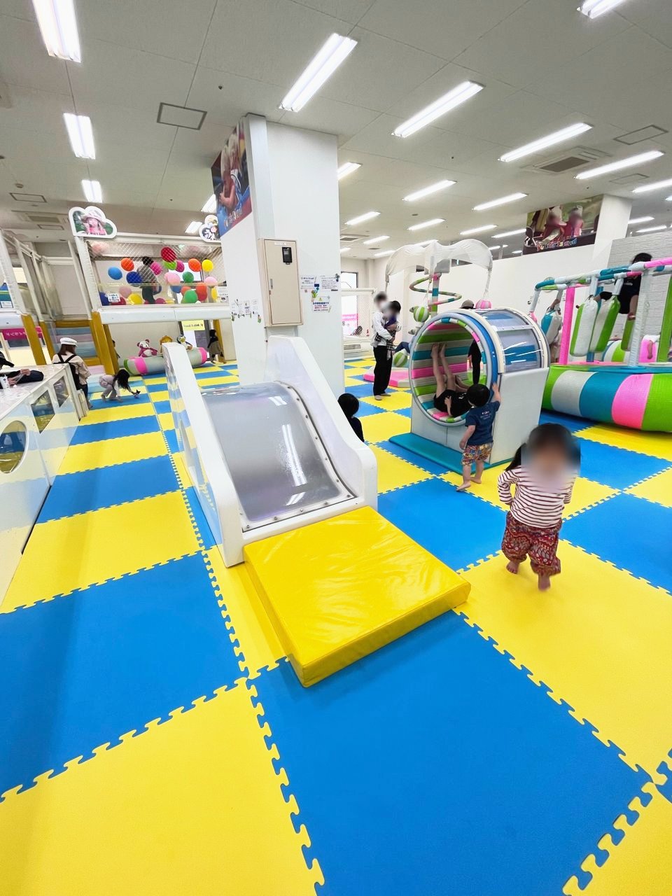 白いすべり台の横を歩く子ども